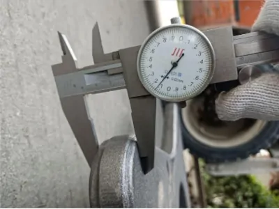 Measuring casting thickness with caliper during quality control